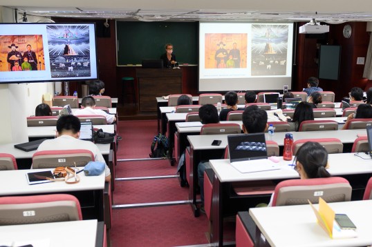 Dr. Powell stands in front of a classroom lecturing